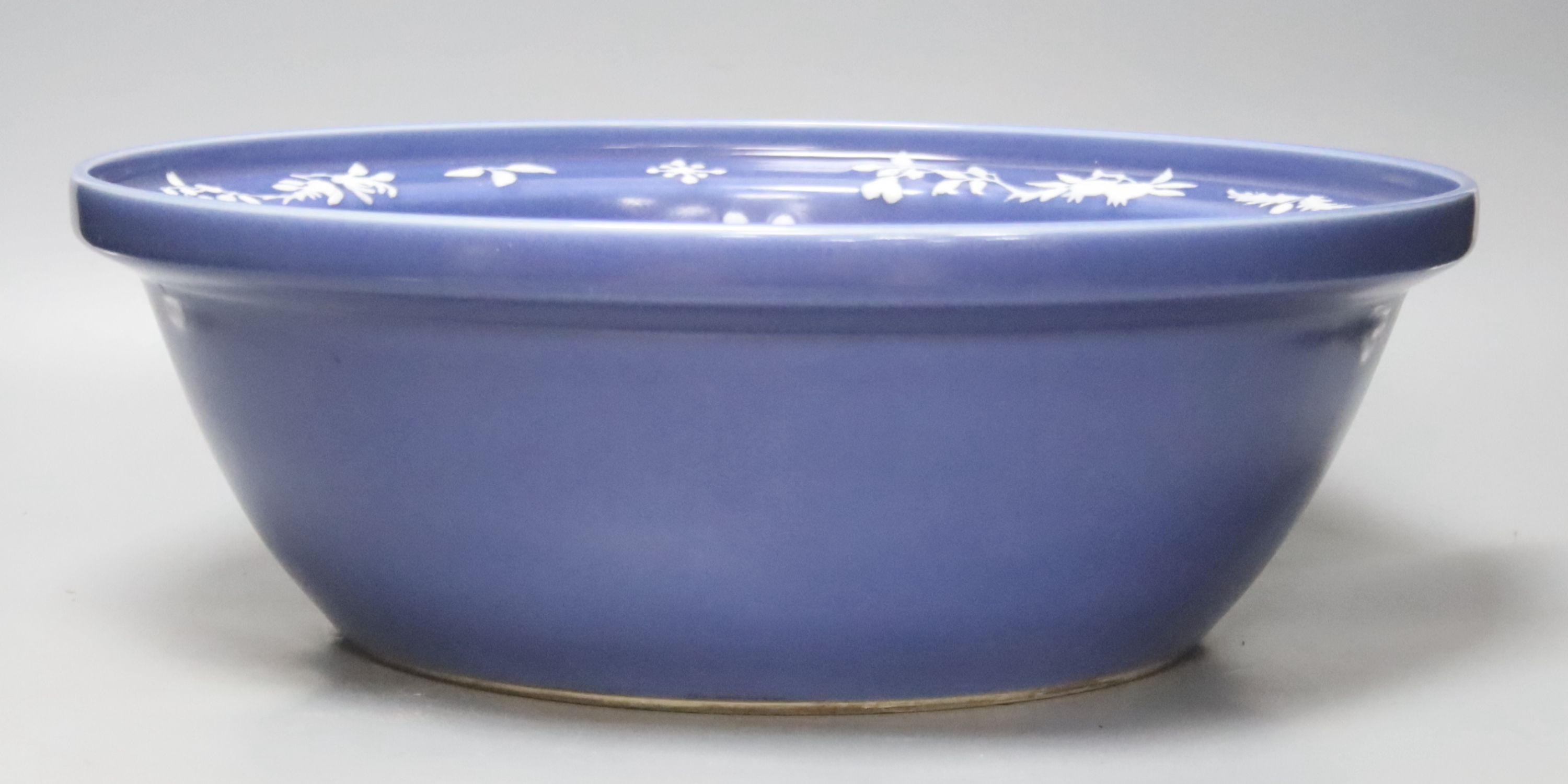 A large Chinese blue and white porcelain basin, lightly relief moulded with plants, 40cm